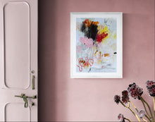 the Framed abstract art on a pink wall with a door and flowers in the foreground