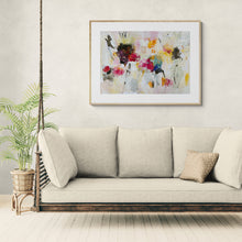 Beige sofa with decorative pillows in a room with the colorful abstract painting on the wall.