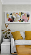 Living room with a white sofa, yellow cushions, and the colorful abstract painting on the wall.